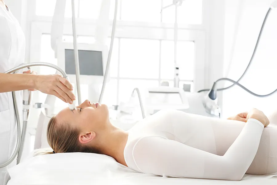 Femme causienne allongée sur une table de massage, remodelage du visage